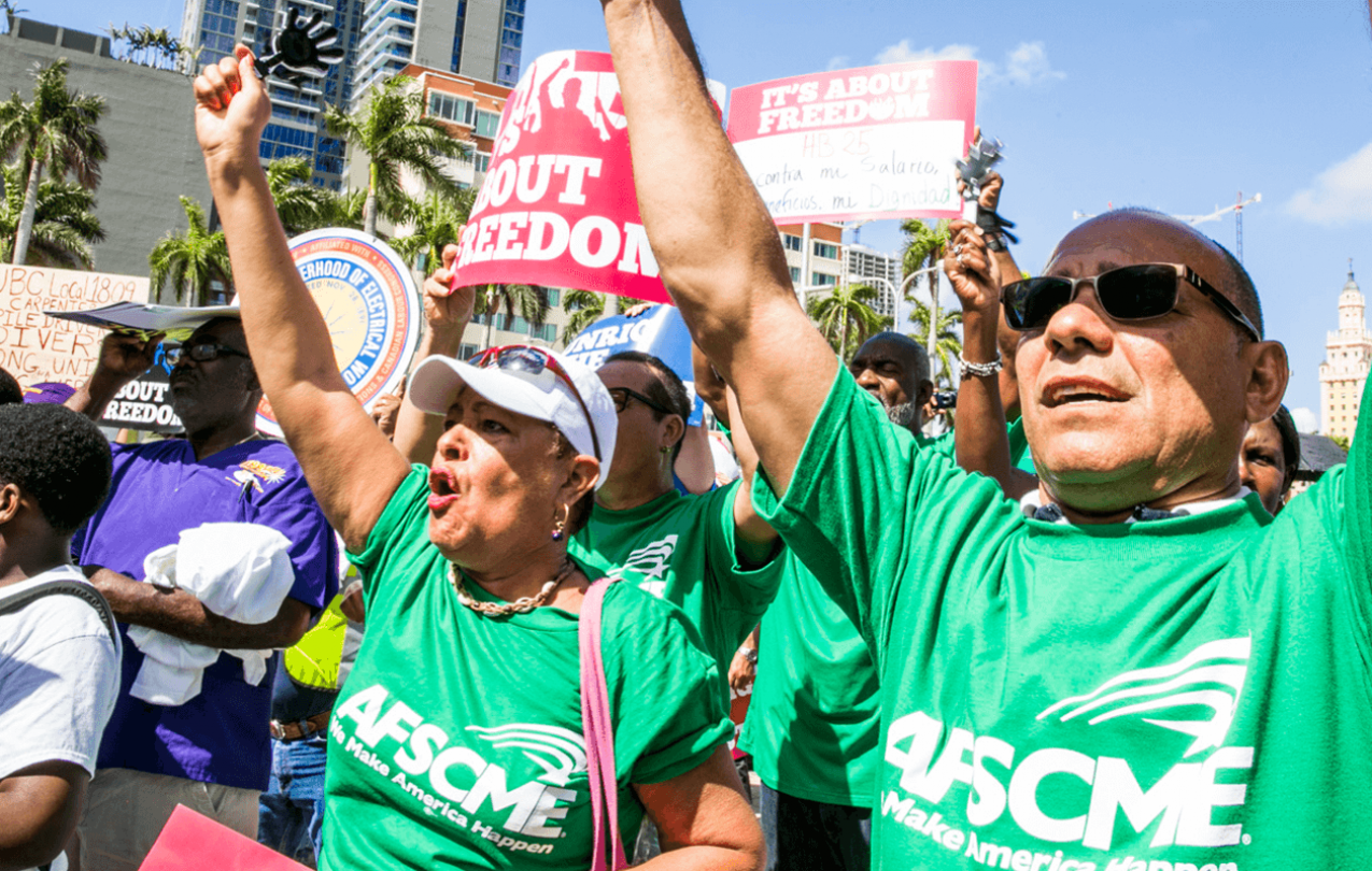 AFSCME members at Florida rally holding signs reading "It's about freedom." 